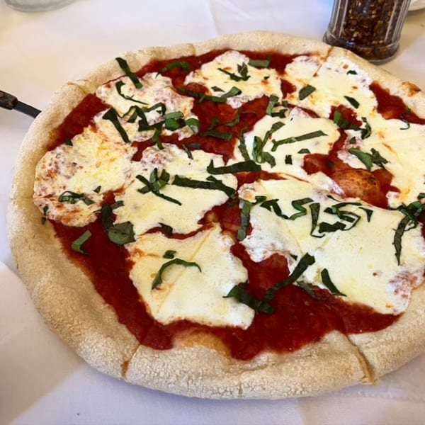 A Rini's Restaurant & Wine Bar Margherita pizza with fresh basil and melted mozzarella cheese.